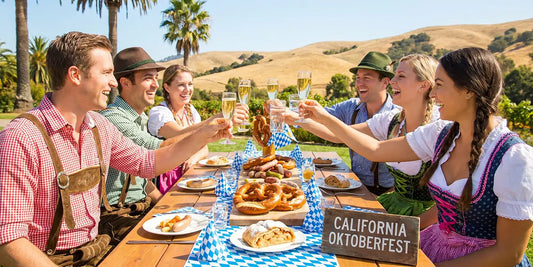 People wearing traditional dirndls and lederhosen raising glasses around a Bavarian-style feast during an Oktoberfest celebration in California