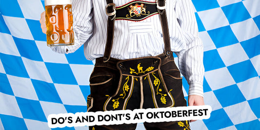 Close-up of a person wearing traditional embroidered lederhosen with suspenders, holding a beer stein against a Bavarian flag backdrop, illustrating essential Oktoberfest do's and don'ts for first-time festival visitors