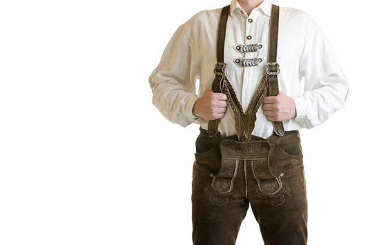 Brown lederhosen with suspenders worn over white shirt with decorative buttons and front flap detail