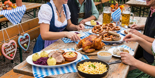 Traditional Oktoberfest meal with roast chicken, bratwurst, pretzels, dumplings, red cabbage, spaetzle, and beer served on a Bavarian-style festival table