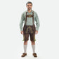 Man wearing walnut brown Lederhosen with green embroidery, checkered Bavarian shirt, knee-high socks, and traditional Haferl shoes