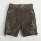 Brown women lederhosen with green embroidered deer and oak leaf motifs, side lacing, and decorative stag belt buckle